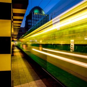 Stadtbahn fährt bei Nacht durch Hannover und zieht Lichtspuren