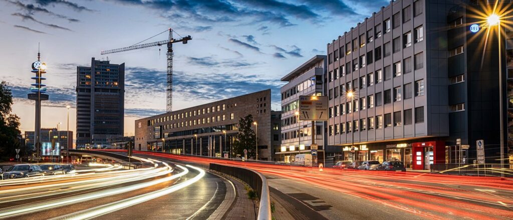 Straße in Hannover mit Lichtspuren und Baukran am Abend