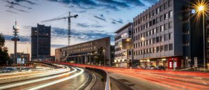 Straße in Hannover mit Lichtspuren und Baukran am Abend